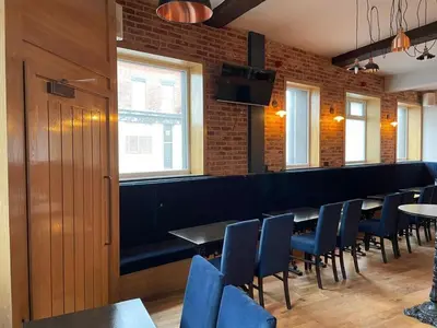 a dining room with blue chairs and a bar at The Royal Crest in Liverpool