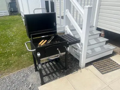 a bbq grill sitting on the steps of a house at 3 Bedroom Modern Caravan Sleeps up to 8 in Millom
