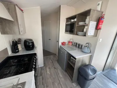 a small kitchen with a sink and a stove at 3 Bedroom Modern Caravan Sleeps up to 8 in Millom