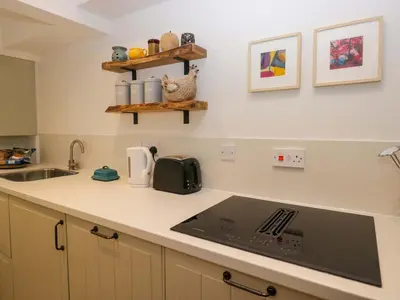 a kitchen with a sink and a stove top oven at 1 Tower House in Grange Over Sands