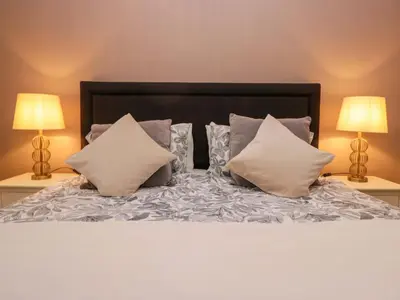 a bedroom with a bed with pillows and two lamps at 1 Tower House in Grange Over Sands