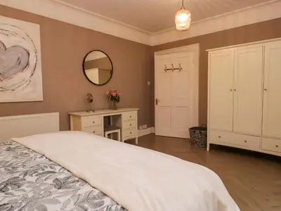 a bedroom with a bed and a desk and a mirror at 1 Tower House in Grange Over Sands