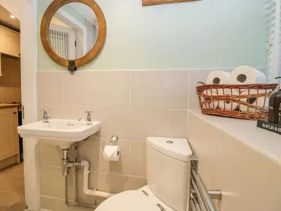 a bathroom with a toilet and a sink and a mirror at 1 Tower House in Grange Over Sands