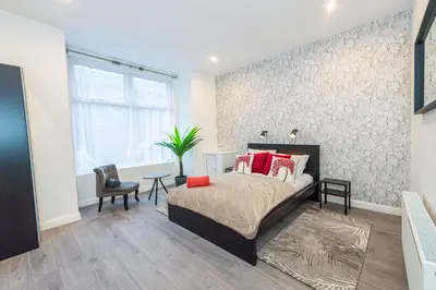 a bedroom with a bed with red pillows on it at The Blossoms Studio Apartments in Liverpool