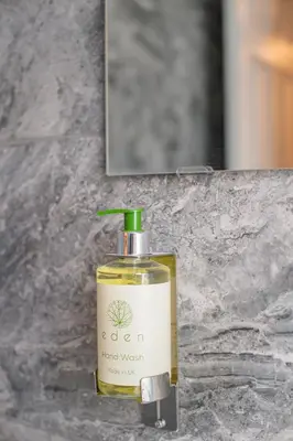 a bottle of oil sitting on a counter next to a mirror at The Blossoms Studio Apartments in Liverpool