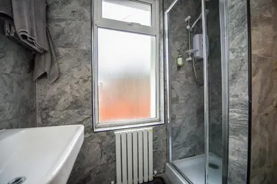 a bathroom with a sink and a window and a shower at The Blossoms Studio Apartments in Liverpool