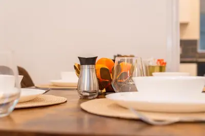 a wooden table with plates and glasses on it at The Blossoms Studio Apartments in Liverpool