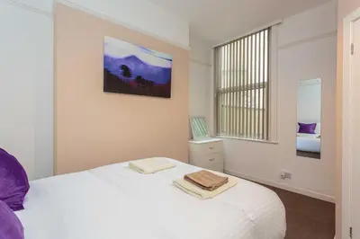 a bedroom with a white bed and a window at Cherry Property - Passionfruit Suite in Blackpool
