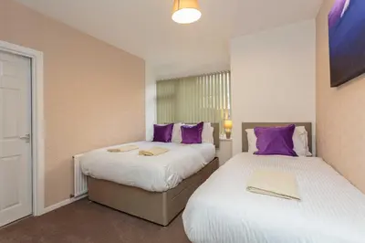two beds in a room with purple pillows at Cherry Property - Passionfruit Suite in Blackpool