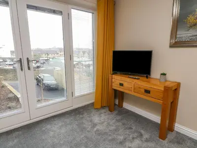 a living room with a tv and a table with a television at Market Lounge in Clitheroe