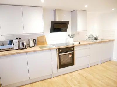 a white kitchen with white cabinets and a microwave at Scandic House, 1 Bed Apartments, Sleeps 2, Ulverston in Ulverston