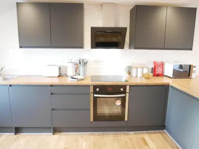 a kitchen with gray cabinets and a wooden counter top at Scandic House, 1 Bed Apartments, Sleeps 2, Ulverston in Ulverston