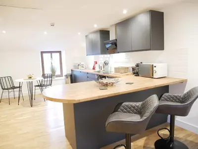 a kitchen with a counter and some chairs in it at Scandic House, 1 Bed Apartments, Sleeps 2, Ulverston in Ulverston