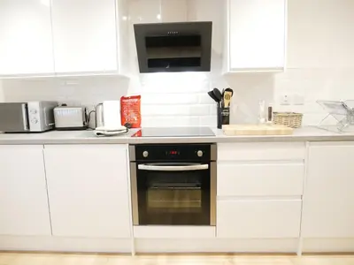 a kitchen with white cabinets and an oven at Scandic House, 1 Bed Apartments, Sleeps 2, Ulverston in Ulverston