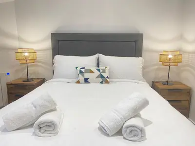 a bedroom with a white bed with towels on it at Scandic House, 1 Bed Apartments, Sleeps 2, Ulverston in Ulverston