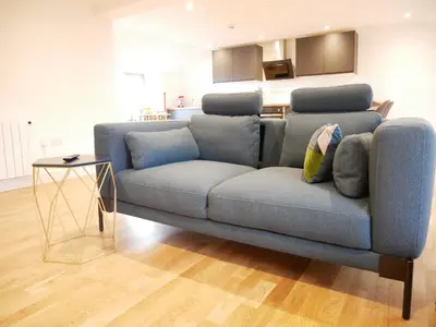 a blue couch in a living room with a kitchen at Scandic House, 1 Bed Apartments, Sleeps 2, Ulverston in Ulverston