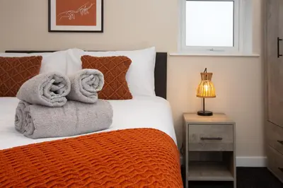 a bedroom with a bed with towels on it at Charles Alexander Short Stay - The Gateway in Blackpool