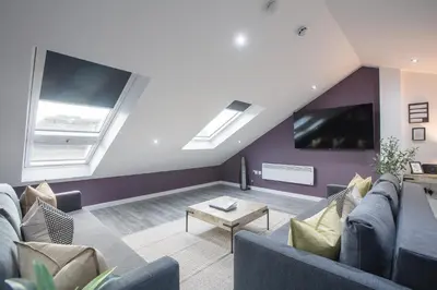 a living room with couches and a flat screen tv at Charles Alexander Short Stay - The Gateway in Blackpool