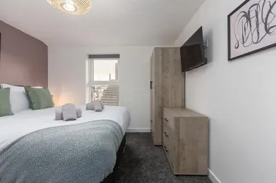 a bedroom with a large bed and a television at Charles Alexander Short Stay - The Gateway in Blackpool