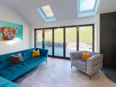 a living room with a blue couch and a chair at Limestone in Ulverston