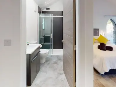a bathroom with a sink and a toilet and a bed at Limestone in Ulverston