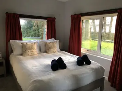 a bed with two black shoes on it in front of a window at Locka Old Hall Cottage in Arkholme