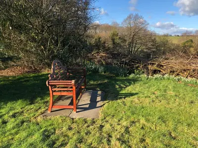 a bench sitting in the grass in a field at Locka Old Hall Cottage in Arkholme
