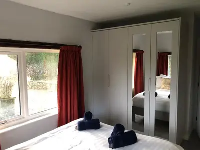 a bedroom with two beds and a window at Locka Old Hall Cottage in Arkholme