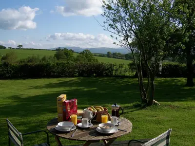 a picnic table with food on it in the grass at Locka Old Hall Cottage in Arkholme