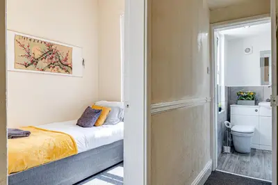 a small bedroom with a bed and a bathroom at Ursula Sparkle Stays in Liverpool