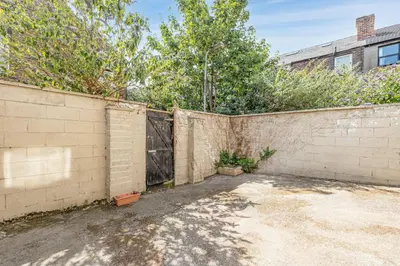 a brick fence with a gate in a yard at Ursula Sparkle Stays in Liverpool