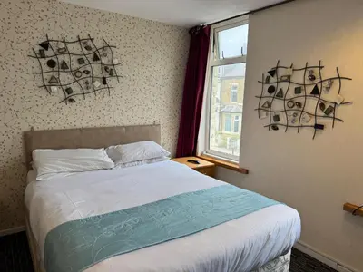 a bedroom with a bed and a window at The Clarendon Hotel in Blackpool