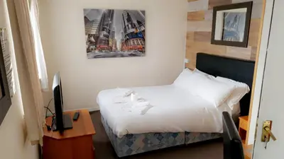 a bedroom with a bed and a picture on the wall at The Clarendon Hotel in Blackpool