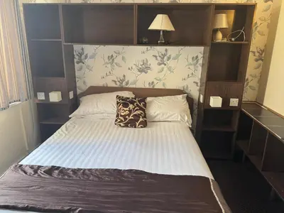 a bedroom with a bed with a wooden headboard at The Clarendon Hotel in Blackpool