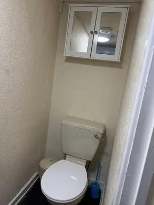 a small bathroom with a toilet and a cabinet at The Clarendon Hotel in Blackpool
