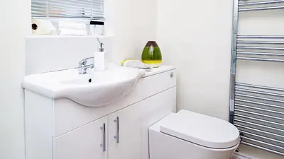a white bathroom with a sink and a toilet at Hibbert Galore in Barrow in Furness