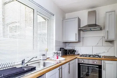 a kitchen with white cabinets and a sink at Hibbert Galore in Barrow in Furness