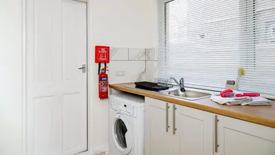 a kitchen with a sink and a washing machine at Hibbert Galore in Barrow in Furness