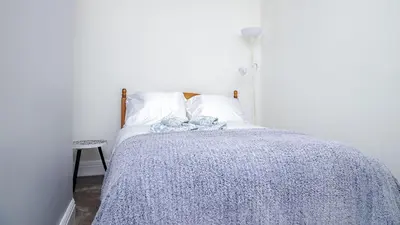 a bedroom with a bed with a blue blanket at Hibbert Galore in Barrow in Furness