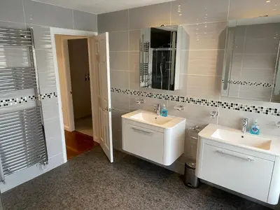 a bathroom with two sinks and a mirror at 'Sounion' - Fabulous, spacious modern house with large private garden in Leafy Lytham in Lytham St Annes
