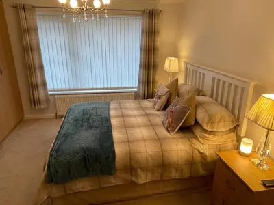 a bedroom with a bed with pillows and a window at 'Sounion' - Fabulous, spacious modern house with large private garden in Leafy Lytham in Lytham St Annes