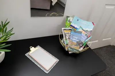 a table with a basket of books and a notebook at The Croston promenade balcony apartment- Morecambe central promenade, beach front and sea views in Morecambe