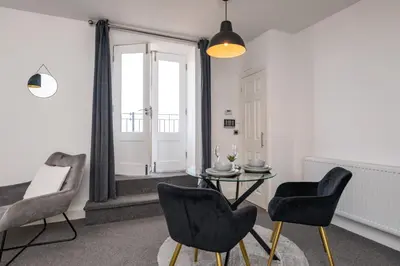 a living room with a table and two chairs at The Croston promenade balcony apartment- Morecambe central promenade, beach front and sea views in Morecambe
