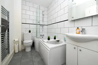 a white bathroom with a toilet and a sink at The Croston promenade balcony apartment- Morecambe central promenade, beach front and sea views in Morecambe