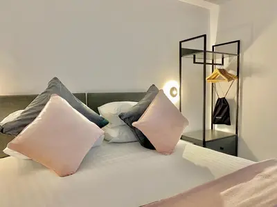 a bed with four pillows on top of it at Eden Retreats Serviced Apartments in Morecambe