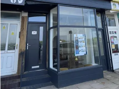 a store front with glass doors on a street at Eden Retreats Serviced Apartments in Morecambe