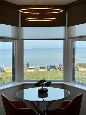 a table in front of a window with a tree on it at Eden Retreats Serviced Apartments in Morecambe
