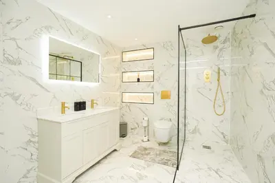 a white bathroom with a shower and a sink at NOVU Apartments Duke Street Liverpool in Liverpool