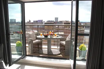 a balcony with a table with drinks on it at NOVU Apartments Duke Street Liverpool in Liverpool