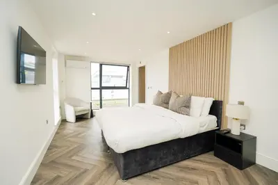 a white bedroom with a large bed and a window at NOVU Apartments Duke Street Liverpool in Liverpool